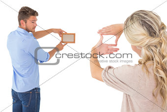 Rear view of young couple hanging up picture frame