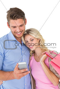 Happy young couple looking at mobile phone