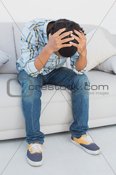 Tensed football fan sitting on couch
