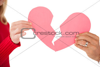 Hands holding two halves of broken heart