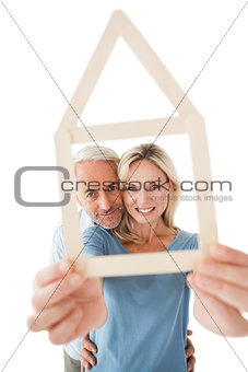 Mature couple looking through house outline