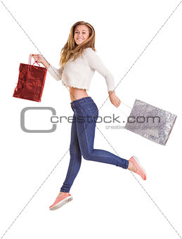 Pretty blonde jumping and holding bags