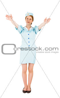 Pretty air hostess with arms raised
