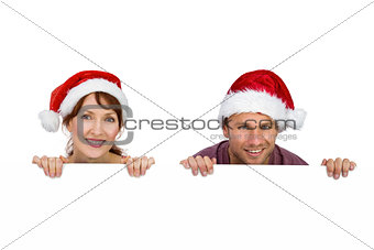 Couple both wearing santa hats