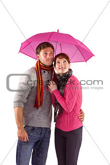 Couple standing underneath an umbrella