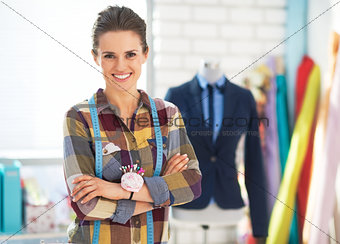 Portrait of happy tailor woman in front of mannequin wearing bus