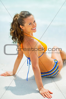 Portrait of relaxed young woman sitting on sea shore