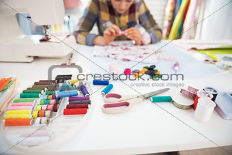 Closeup on working desk and tailor woman in background