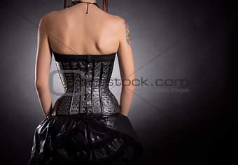 Back view of woman in silver leather corset 