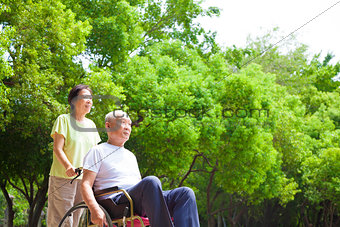 Asian senior man sitting on a wheelchair with his wife