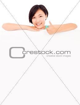 smiling pretty young girl thumb up with blank board