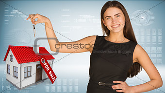 Beautiful woman with keys and small house