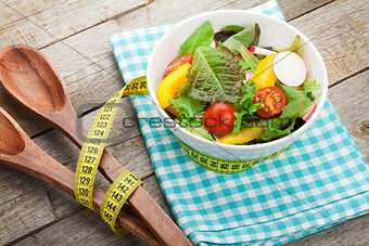 Fresh healthy salad and kitchen utensil