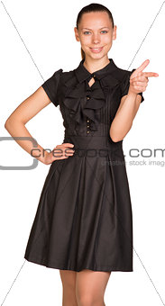 Beautiful business woman in black dress pointing at copy space