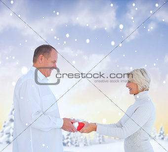 Composite image of couple exchanging gift