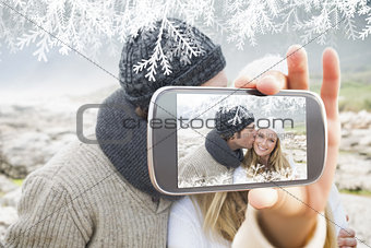 Composite image of hand holding smartphone