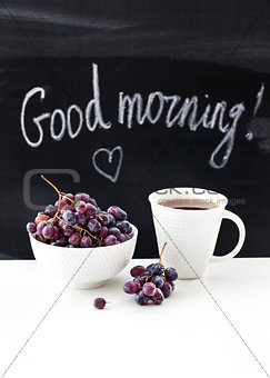 Coffee mug and fresh grape on the table