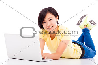 happy young girl lying on the floor with a laptop