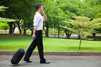 businessman walking and using a phone on the road