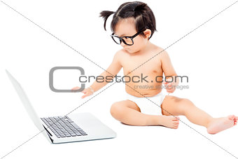 little child sitting playing on a laptop. isolated on white