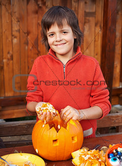Closeup of boy carving Halloween jack-o-lantern