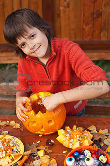 Boy preparing for Halloween - carving a jack-o-lantern