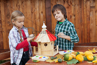 Kids painting a bird house