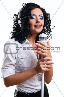 Beautiful young woman with headphones and microphone over white 