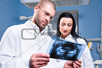 Dentist and assistant checking x-ray at dental clinic