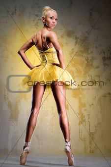 Beautiful ballerina in yellow tutu on point
