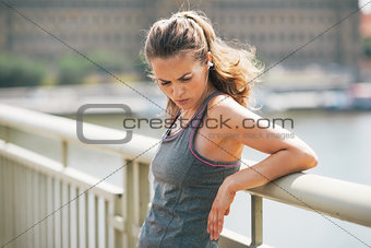 Portrait of tired fitness young woman in the city