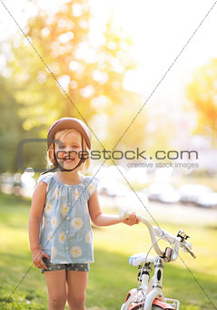 Portrait of happy baby girl with bicycle