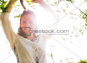 Portrait of happy young woman in foliage