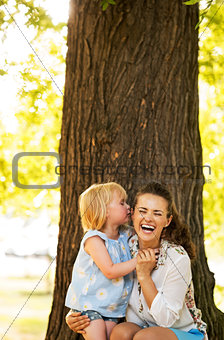 Portrait of happy mother and baby girl having fun in park