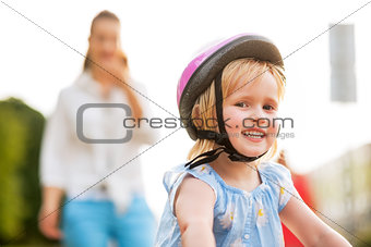 Portrait of smiling baby girl riding bicycle