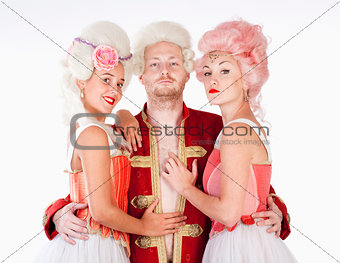 Two Female Friends in Historical Costumes Embracing a Man