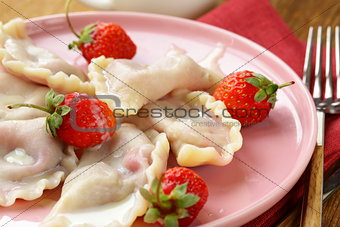 dumplings with berries and cream sauce served with fresh strawberries