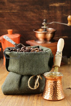 Still life coffee beans in a bag and copper coffee pot