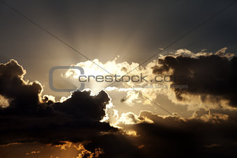 Sunset sky with dark clouds and sun rays