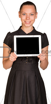 Beautiful girl in dress holding tablet and looking at camera
