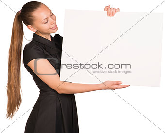 Beautiful girl holding blank white placard and looking at it