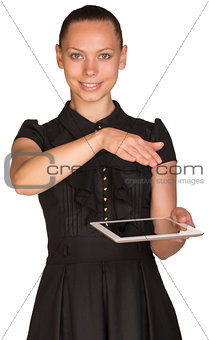 Beautiful girl in dress holding tablet and covers it