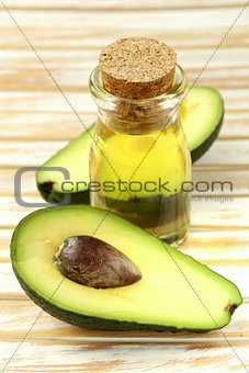 oil of avocado and fresh fruit on wooden table