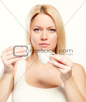 Attractive blond woman holding cup of coffee and cream