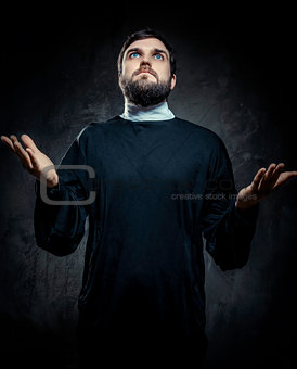 Portrait of priest against dark background