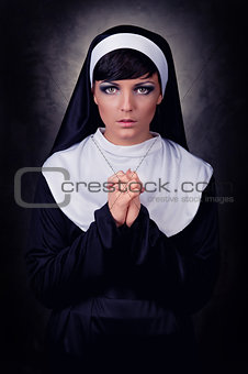 Young attractive nun praying