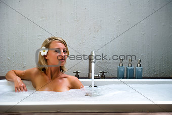 Beautiful young woman taking a bubble bath