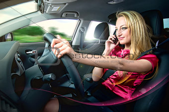 Woman sitting in a car and talking by mobile telephone