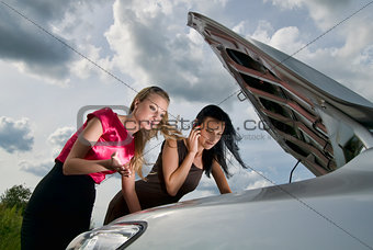 Two young women with broken car