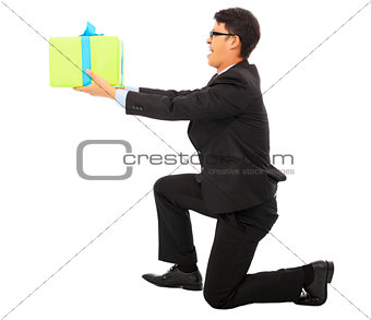 young Business man holding a gift box and kneel. 